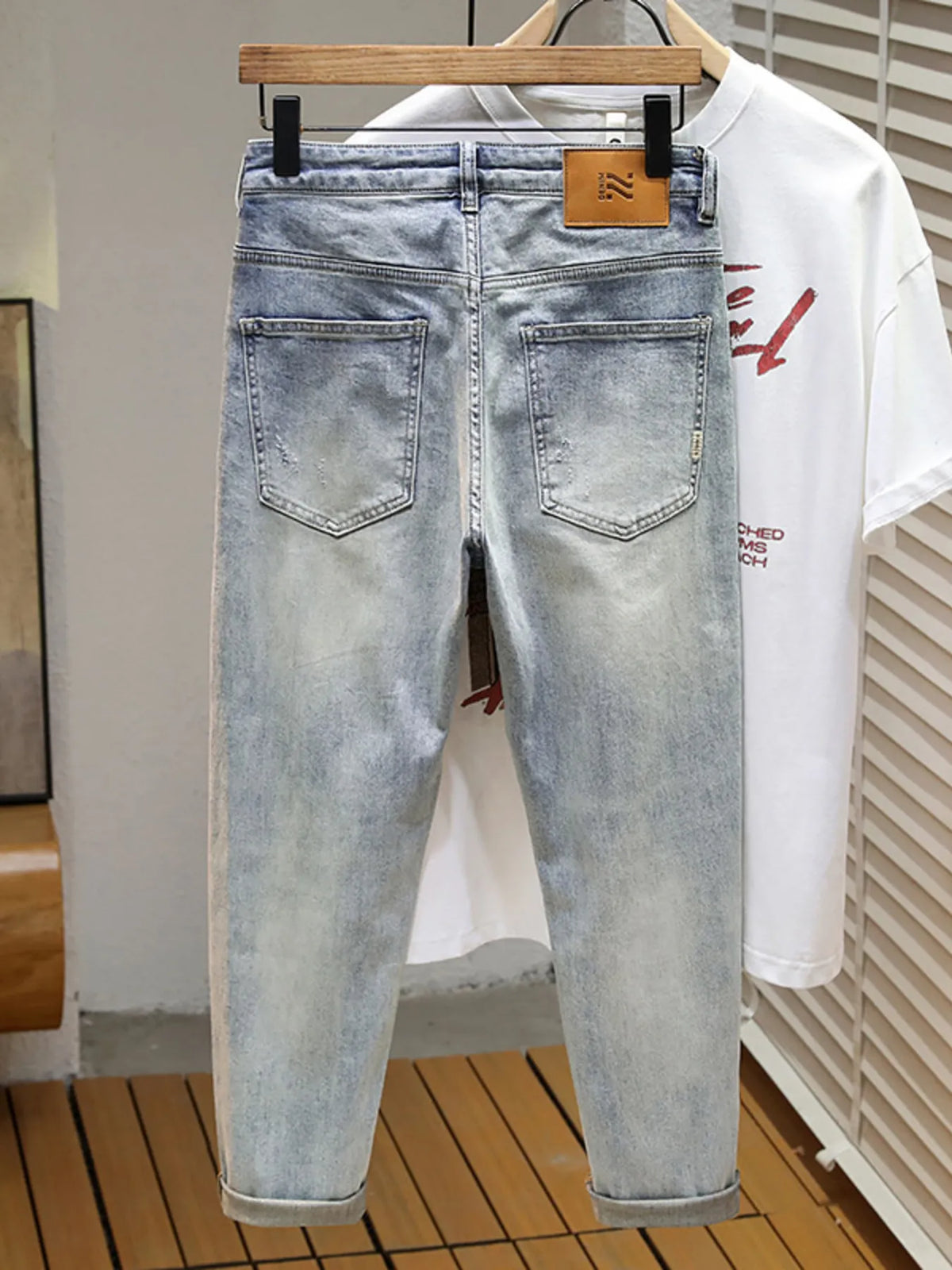 Men's distressed wide leg jeans in washed blue denim with knee rips, 90s grunge style