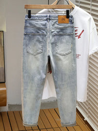 Men's distressed wide leg jeans in washed blue denim with knee rips, 90s grunge style