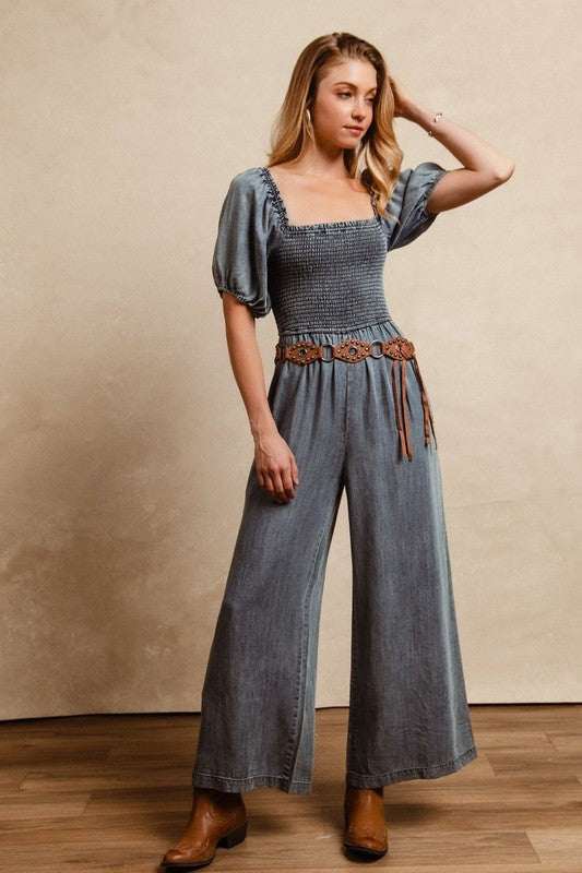BiBi Smocked Denim Jumpsuit with square neck and puff sleeves on model