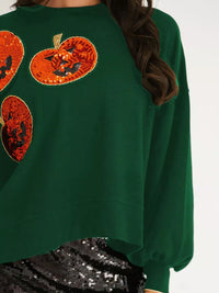 Spooky Pumpkin Sequin Sweatshirt reversible from pumpkin to moon and bats design on a model