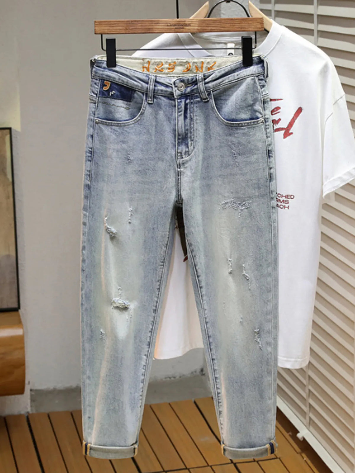Men's distressed wide leg jeans in washed blue denim with knee rips, 90s grunge style