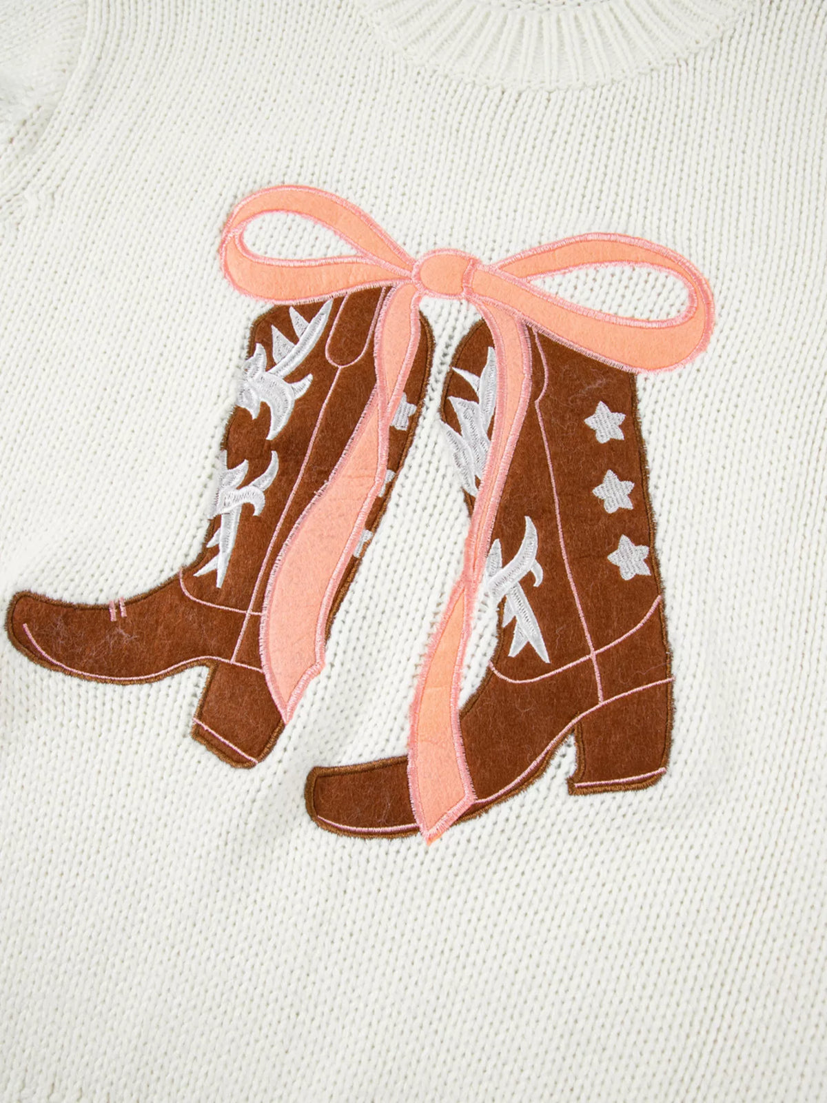 Women's Embroidered Bow Boots Drop Shoulder Sweater in cream, laid flat showing the detailed boot and bow design on the front.