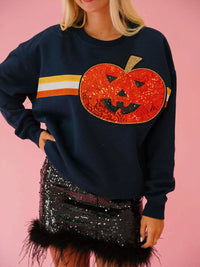 Spooky Halloween Sequin Sweatshirt showing the reversible design from black with orange sequins to orange with black sequins.