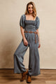BiBi Smocked Denim Jumpsuit with square neck and puff sleeves on model