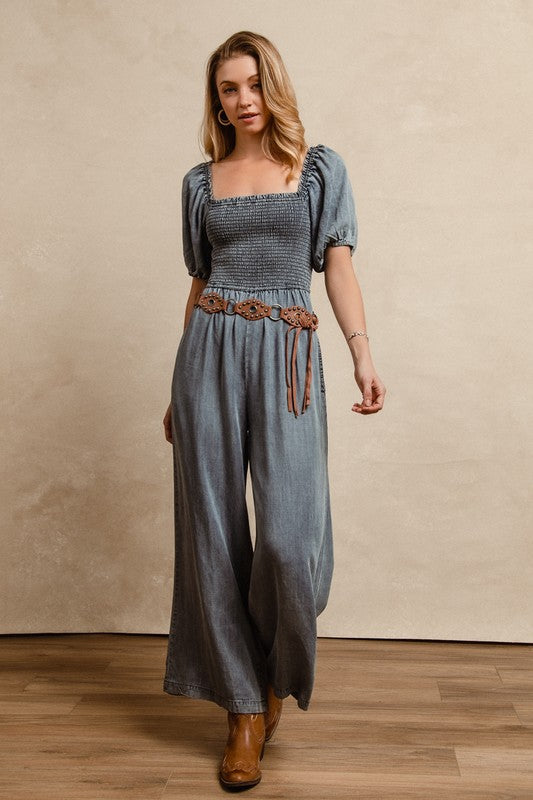 BiBi Smocked Denim Jumpsuit with square neck and puff sleeves on model