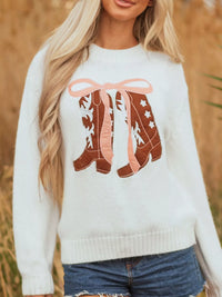 Women's Embroidered Bow Boots Drop Shoulder Sweater in cream, laid flat showing the detailed boot and bow design on the front.