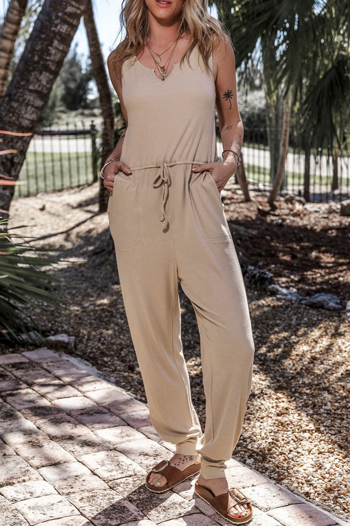 American woman wearing a stylish drawstring notched wide strap jumpsuit in tan