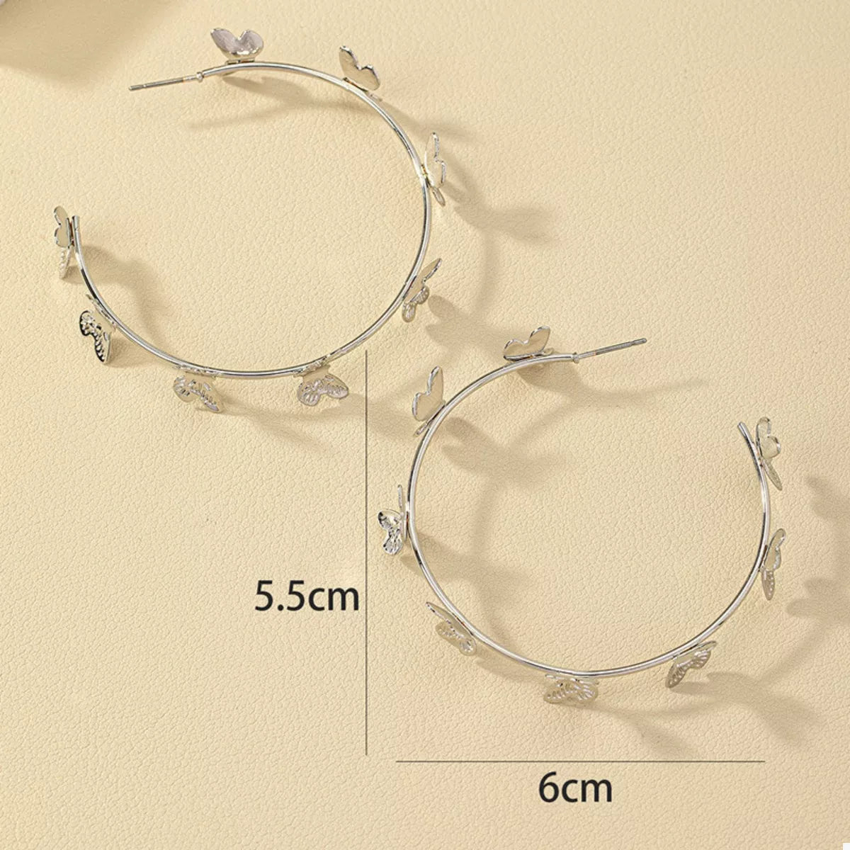 Butterfly Vine Hoop Earrings in 18K gold-plated metal, shown on a woman's ear.
