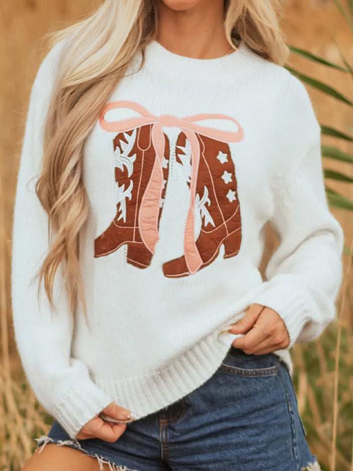 Women's Embroidered Bow Boots Drop Shoulder Sweater in cream, laid flat showing the detailed boot and bow design on the front.