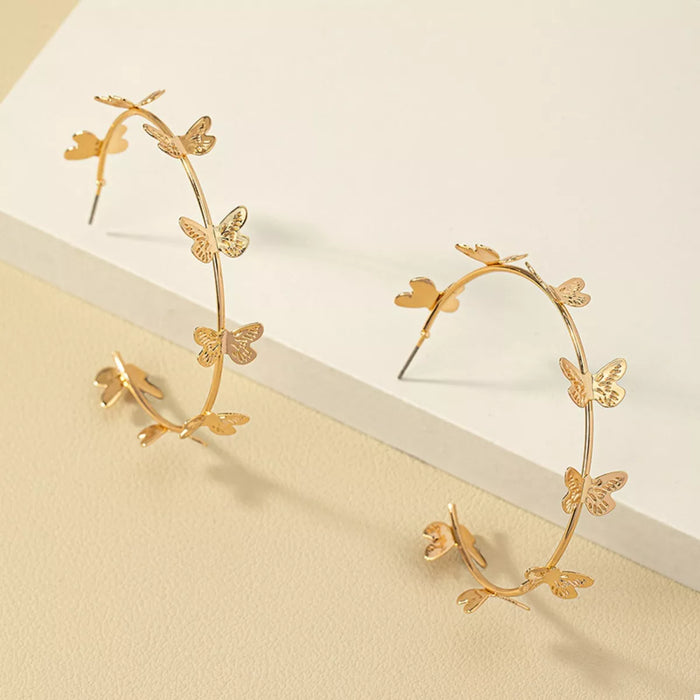 Butterfly Vine Hoop Earrings in 18K gold-plated metal, shown on a woman's ear.