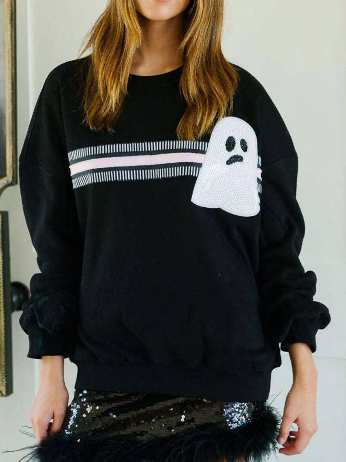 Spooky Halloween Sequin Sweatshirt showing the reversible design from black with orange sequins to orange with black sequins.
