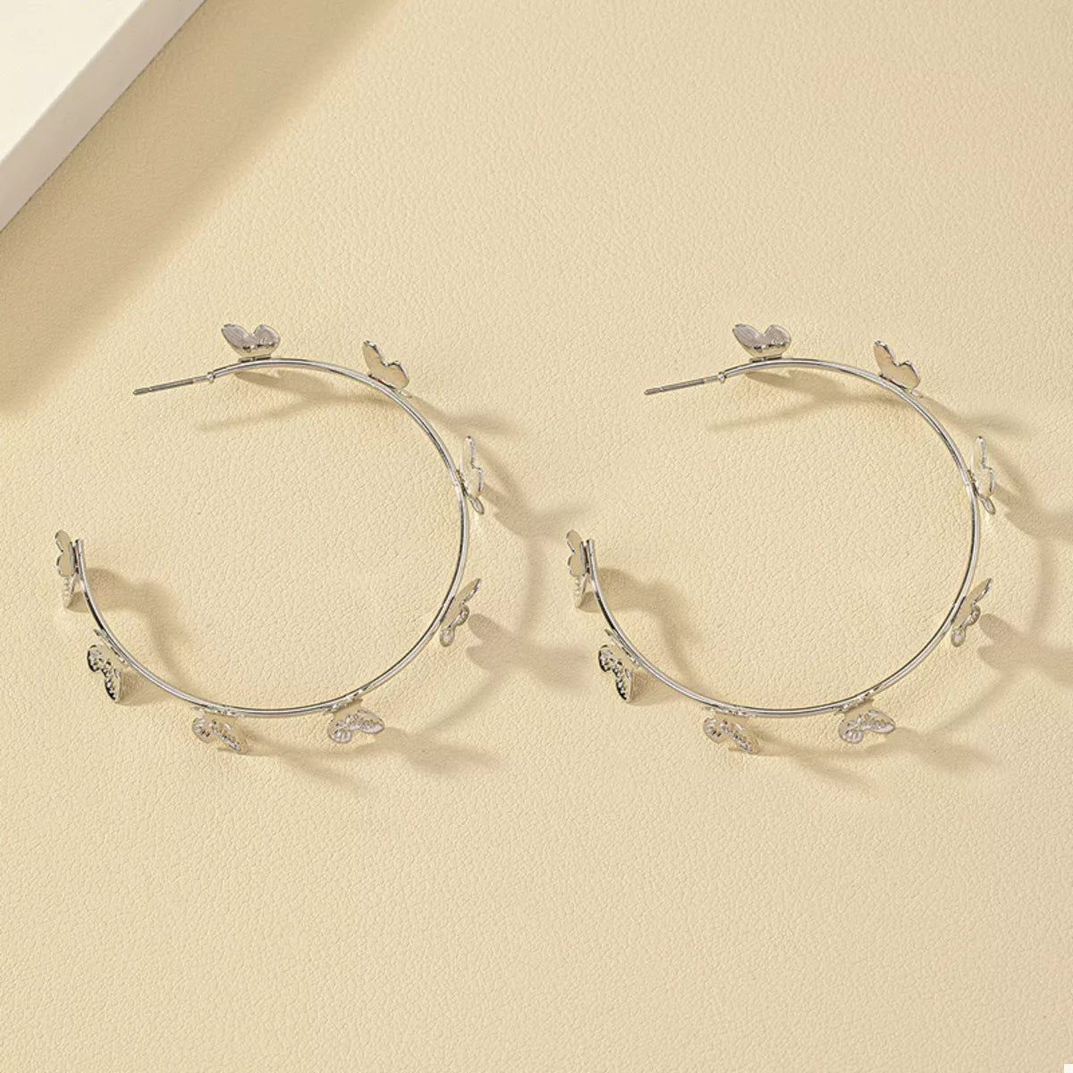 Butterfly Vine Hoop Earrings in 18K gold-plated metal, shown on a woman's ear.