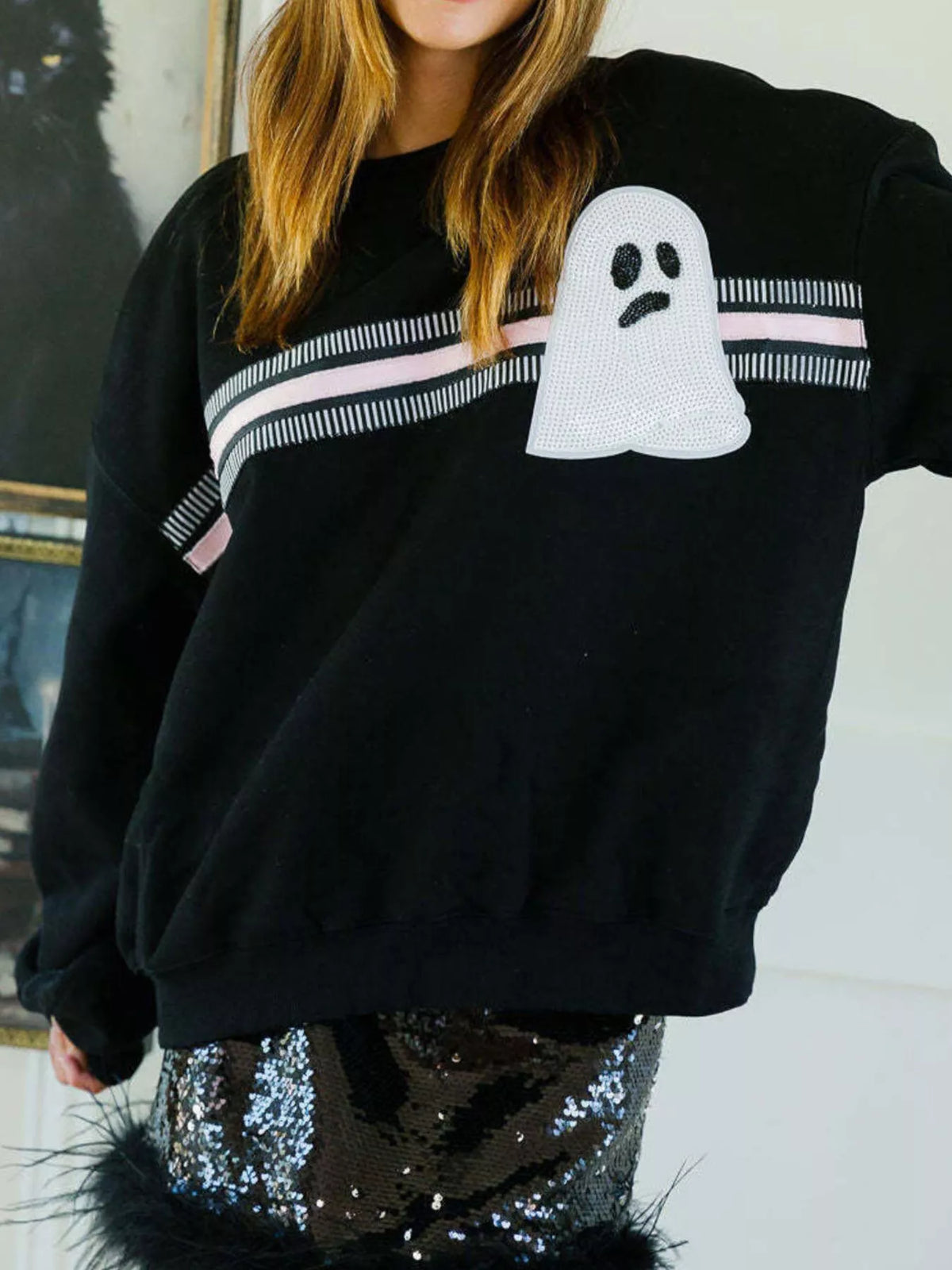Spooky Halloween Sequin Sweatshirt showing the reversible design from black with orange sequins to orange with black sequins.