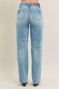 Judy Blue 90s Straight Jeans in a distressed wash, modeled from the front, showing the high waist and straight leg fit.