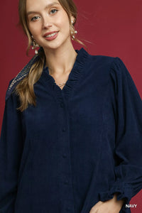 Close up detail of ruffle trim and button front on corduroy shirt