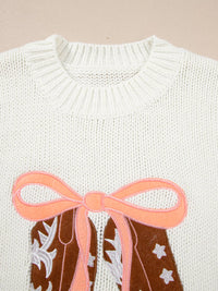 Women's Embroidered Bow Boots Drop Shoulder Sweater in cream, laid flat showing the detailed boot and bow design on the front.
