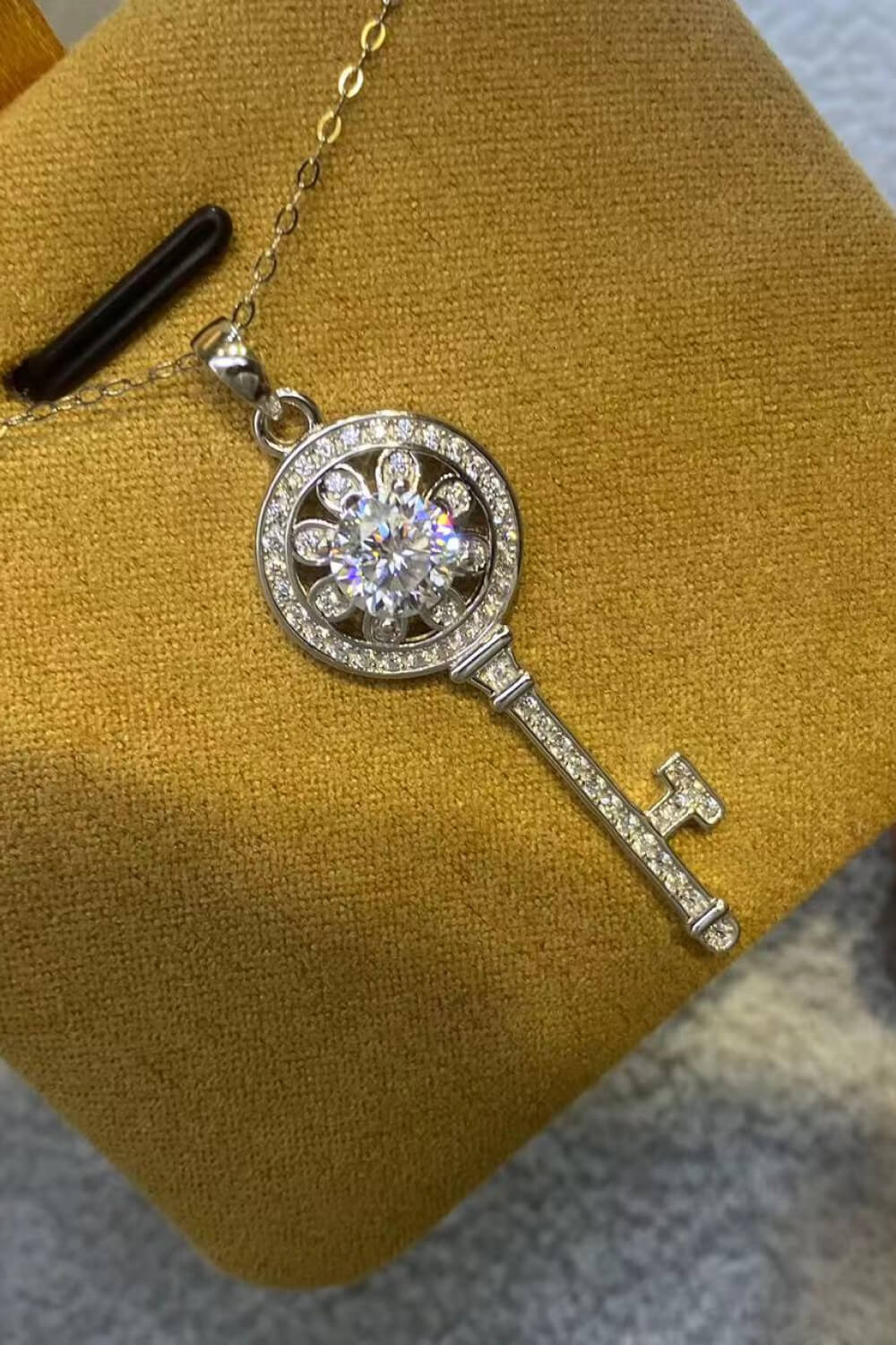 Moissanite Key Pendant Necklace - Platinum Plated with sparkling design on a yellow display.