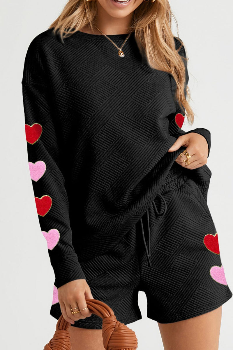 A stylish two-piece set featuring a round neck top with a heart texture design and matching drawstring shorts, perfect for casual or loungewear.